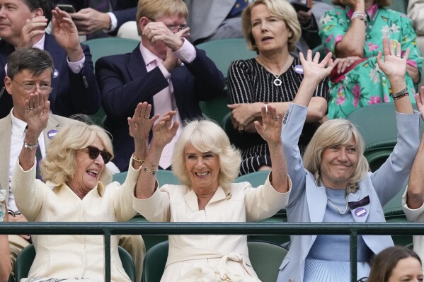Britain's Queen Camilla, centre, reacts with the crowd during the Taylor Fritz of the United States and Lorenzo Musetti of Italy quarterfinal match at the Wimbledon tennis championships in London, Wednesday, July 10, 2024. (AP Photo/Alberto Pezzali)