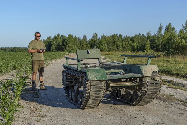 Andrii Denysenko, CEO of design and production bureau "UkrPrototyp", stands by Odyssey, an 800-kilogram (1,750-pound) ground drone prototype, at a corn field in northern Ukraine, Friday, June 28, 2024. Facing manpower shortages and uneven international assistance, Ukraine is struggling to halt Russia’s incremental but pounding advance in the east and is counting heavily on innovation at home. (AP Photo/Anton Shtuka)
