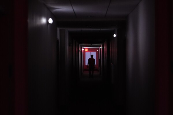 A hotel guest navigates the halls after power was lost due to Hurricane Beryl, July 8, 2024, in Bay City, Texas. (AP Photo/Eric Gay)