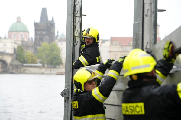 Firefighters adjust parts of the anti-flood barriers in Prague, Czech Republic, Friday, Sept. 13, 2024. (AP Photo/Petr David Josek)