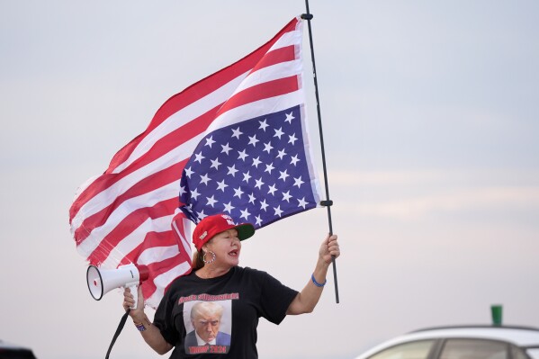 Supporter of former President Donald Trump, Maria Korynsel, demonstrates near Trump's Mar-a-Lago estate, Thursday, May 30, 2024, in Palm Beach, Fla.  (AP Photo/Wilfredo Lee)