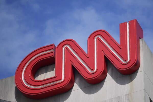 FILE - The CNN sign is seen, April 21, 2022, in Atlanta. CNN announced Wednesday, July 10, 2024, that it is eliminating approximately 100 jobs and plans to debut its first digital subscriptions before the end of the year as the news network leans into reshaping its business. (AP Photo/Mike Stewart, File)