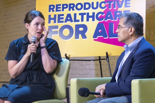 U.S. Health Secretary Xavier Becerra, right, listens as Jillaine St. Michel, a patient who was forced to travel to Seattle to access an abortion speaks during a conversation with local patients and providers who have been impacted by Idaho's abortion restrictions held at the Linen Building in Boise, Idaho, Wednesday, June 26, 2024. (AP Photo/Kyle Green)