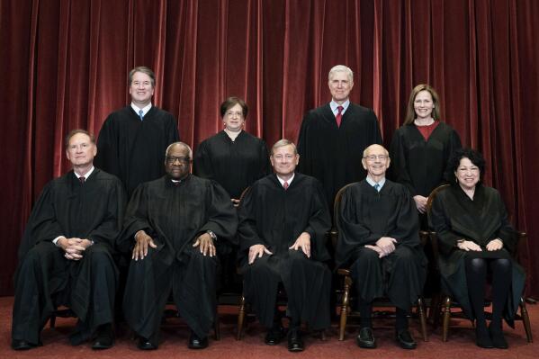 FILE - Members of the Supreme Court pose for a group photo at the Supreme Court in Washington, April 23, 2021. Seated from left are Associate Justice Samuel Alito, Associate Justice Clarence Thomas, Chief Justice John Roberts, Associate Justice Stephen Breyer and Associate Justice Sonia Sotomayor, Standing from left are Associate Justice Brett Kavanaugh, Associate Justice Elena Kagan, Associate Justice Neil Gorsuch and Associate Justice Amy Coney Barrett. The Supreme Court says it will continue providing live audio broadcasts of arguments in cases, even as it welcomes the public back to its courtroom for a new term that begins Monday. (Erin Schaff/The New York Times via AP, Pool)