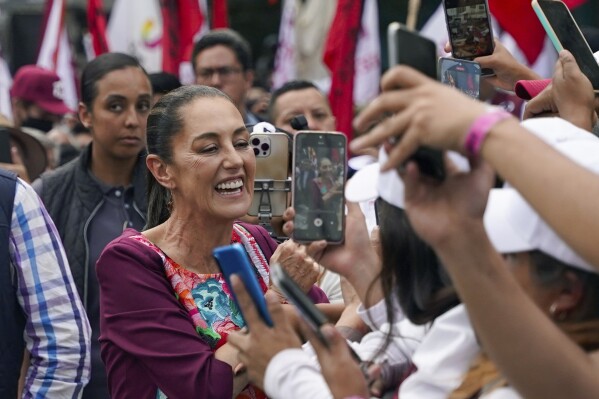 FILE - Presidential candidate Claudia Sheinbaum greets supporters during her opening campaign rally at the Zocalo in Mexico City, March 1, 2024. Masked men stopped a vehicle carrying Sheinbaum, Mexico’s leading presidential candidate, while she was traveling between campaign stops Sunday, April 21, to ask that she address the violence in the southern state of Chiapas if she wins the June 2 election. (AP Photo/Aurea Del Rosario, File)