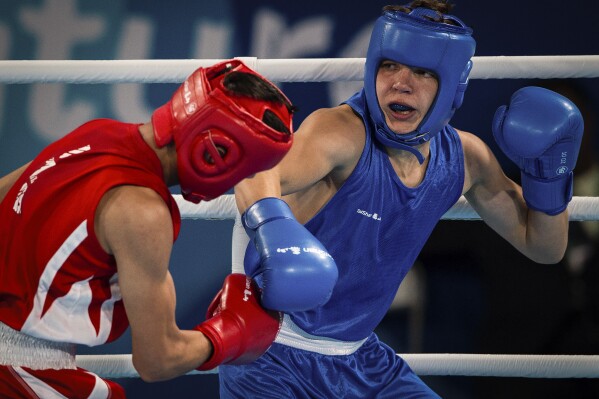 In this photo provided by the International Olympic Committee, Maksym Halinichev of Ukraine, right, competes against Abdumalik Khalokov of Uzbekistan in the Boxing Men's Bantam (56kg) Gold Medal Bout at the Oceania Pavilion of Youth Olympic Park during the Youth Olympic Games in Buenos Aires, Argentina, Thursday, Oct. 18, 2018. As one of Ukraine’s most promising boxing prospects, Halinichev could have been shielded from the war. (Jonathan Nackstrand/IOC via AP)