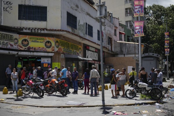 Residents line up at a bakery in Caracas, Venezuela, Tuesday, July 30, 2024, two days after the disputed presidential election. (AP Photo/Fernando Vergara)