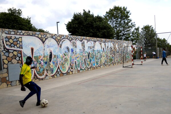 Young men kicks balls on a concrete soccer field in Mataro, Spain, July 12, 2024 where Spain player Lamine Yamal once played in his Rocafonda neighborhood. The peculiar hand sign Yamal made after scoring his first goals for club and country represent the last three digits of the postal code of Rocafonda: 304. (AP Photo/Joan Monfort)