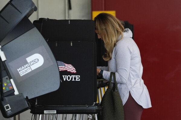 FILE - Voter Maria Mendoza completes her ballot for Florida's primary election behind a privacy screen, Tuesday, Aug. 20, 2024, at a polling place inside a fire station in Coral Gables, Fla. (AP Photo/Rebecca Blackwell, File)