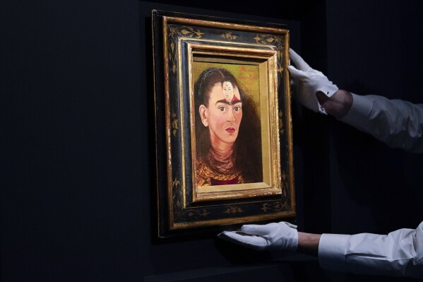 FILE - An art handler adjusts Frida Kahlo's “Diego and I” on display at Sotheby's auction house during a press preview for the Modern Evening auction, Nov. 5, 2021, in New York. The 70th anniversary of Kahlo’s death is on July 13, 2024. (AP Photo/Mary Altaffer, File)