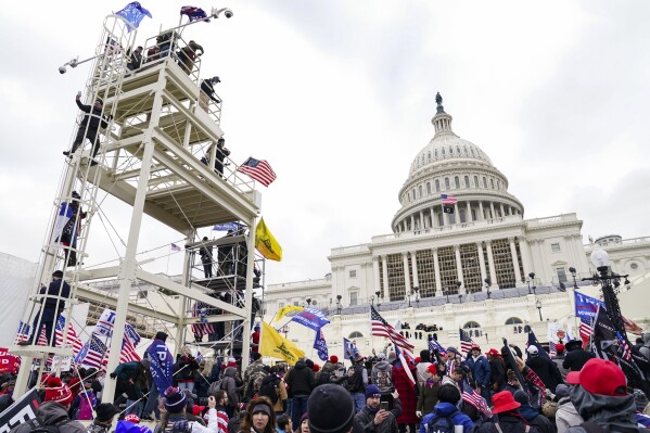 FILE - Violent insurrectionists breach the U.S. Capitol in Washington, Jan. 6, 2021. A former government employee has been charged with repeatedly submitting fake tips to the FBI reporting that several of his co-workers in the intelligence community were part of a mob that attacked the U.S. Capitol on Jan. 6. Court records unsealed on Friday, May 3, 2024, say that Miguel Eugenio Zapata was arrested in Chantilly, Virginia, on Thursday on a charge that he made false statements to law enforcement. (AP Photo/John Minchillo, File)