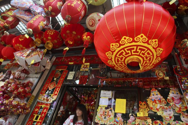 FILE - This Feb. 6, 2013 file photo shows a woman walking out a shop selling seasonal items ahead of Chinese New Year in Chinatown in Bangkok, Thailand. In many Asian cultures, the Lunar New Year is a celebration marking the arrival of spring and the start of a new year on the lunisolar calendar. It's the most important holiday in China where it's observed as the Spring Festival. It's also celebrated in South Korea, Vietnam and diaspora communities around the world. (AP Photo/Sakchai Lalit, File)