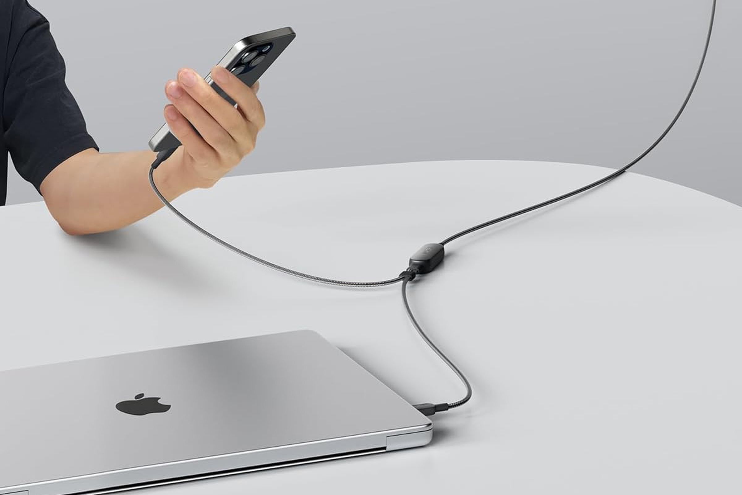 An Apple MacBook and iPhone being simultaneously charged using Anker’s new 2-in-1 USB-C cable.