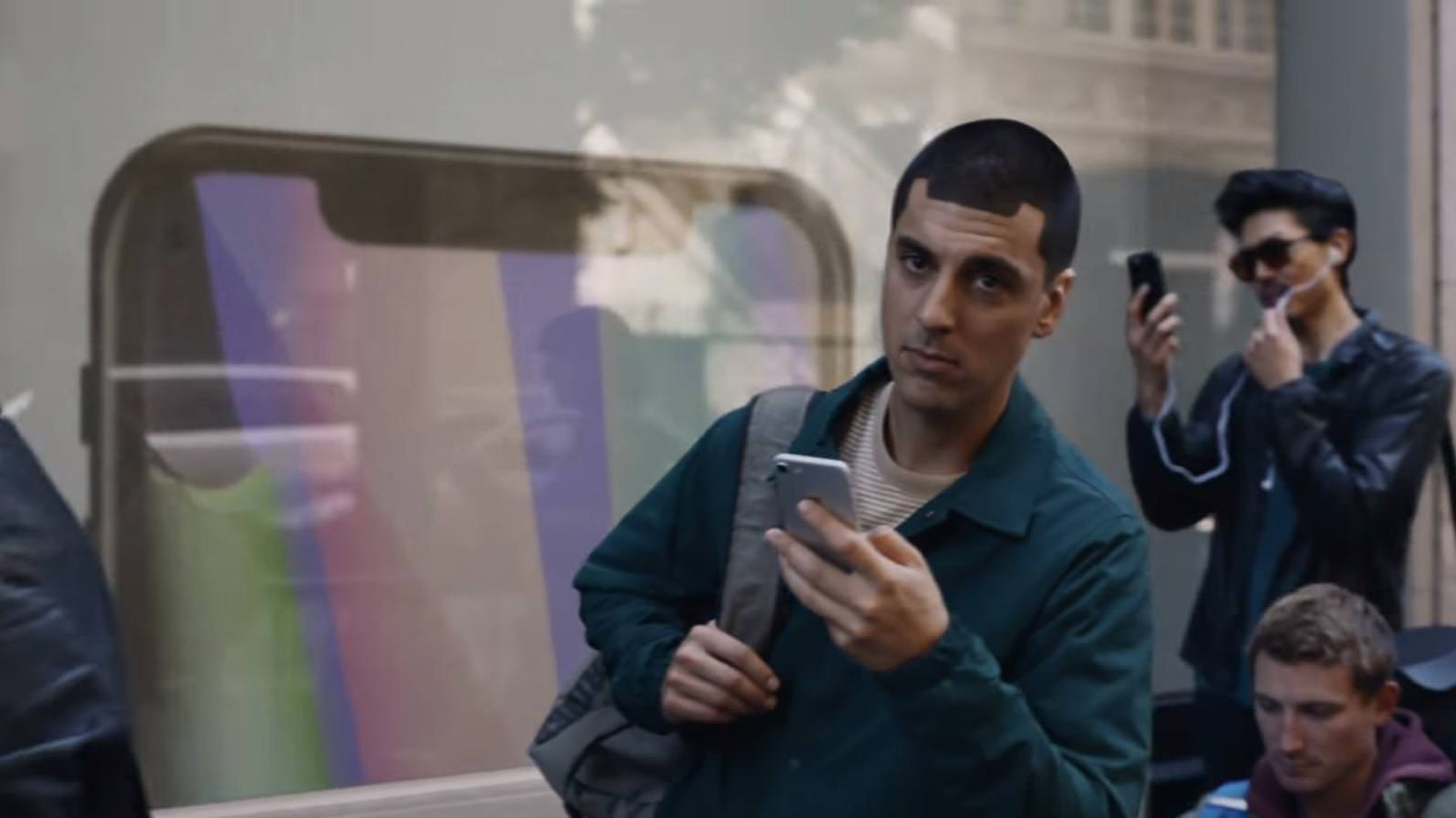 A still from a Samsung ad showing a man with his hair cut to look like notch on the top of an iPhone X.