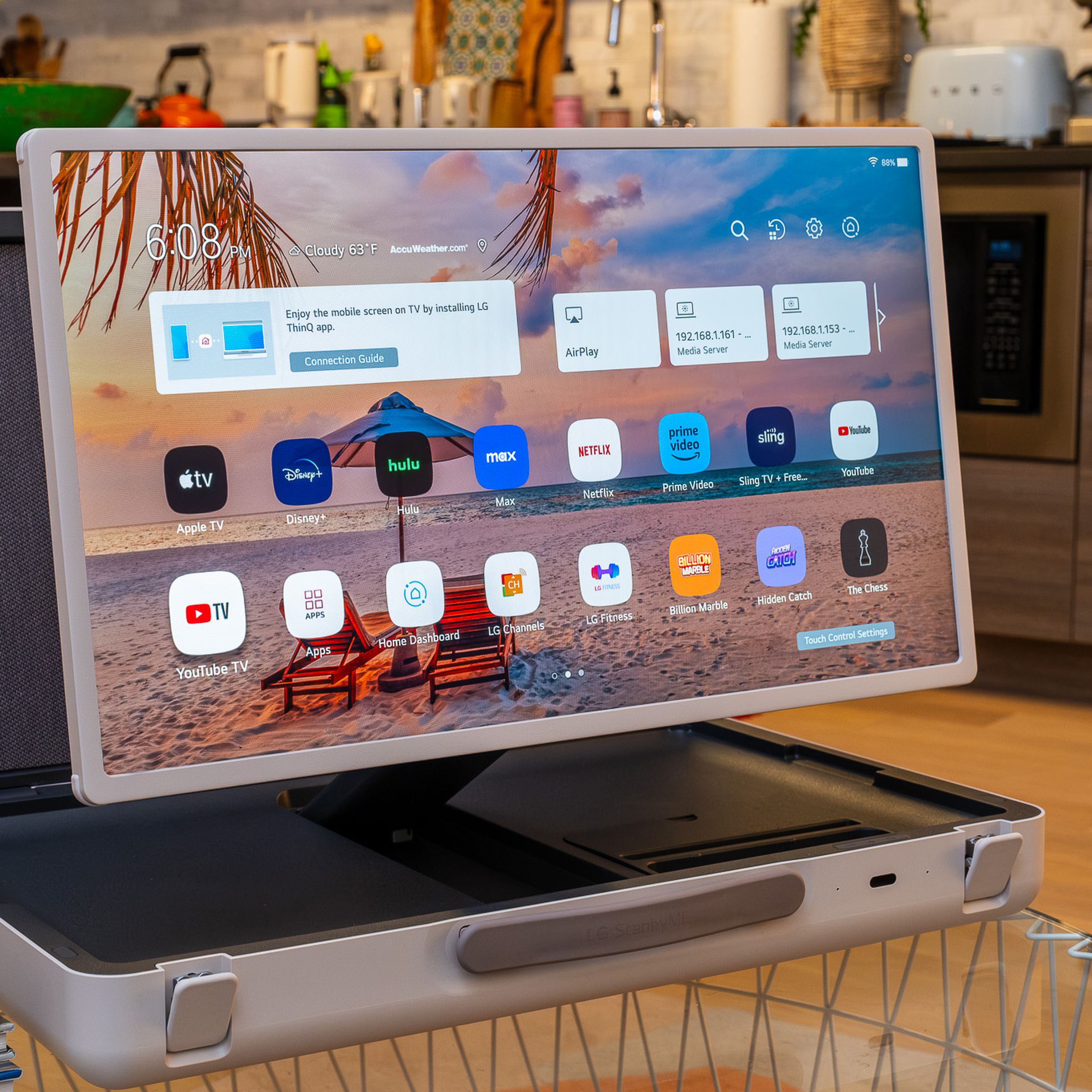 A photo of LG’s StanbyME Go briefcase TV on a living room table with kitchenware in the background.