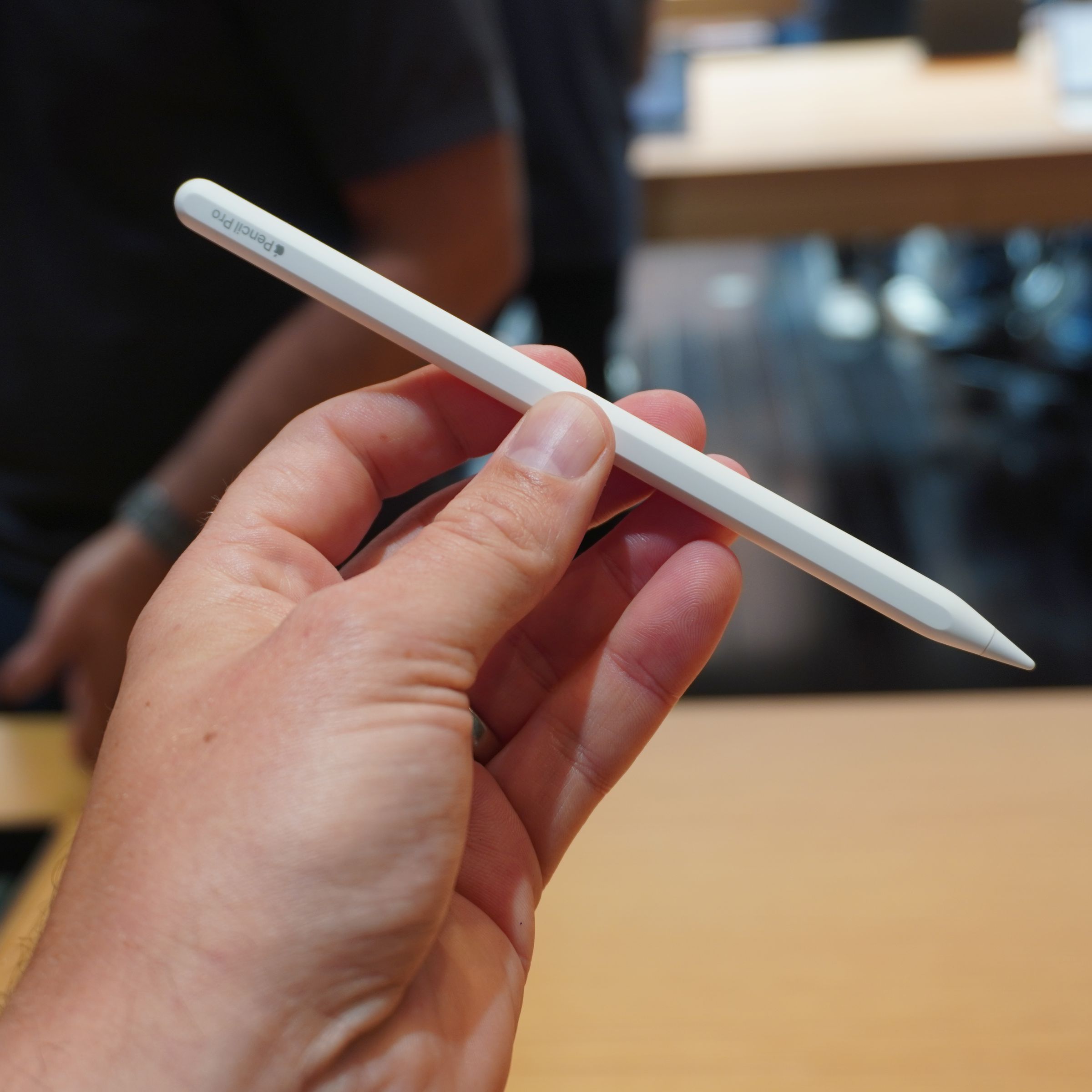 A photo of a hand holding an Apple Pencil Pro.