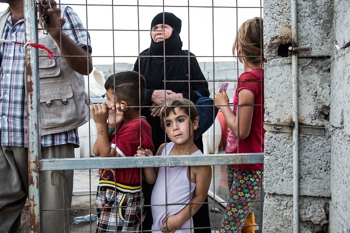 Displaced Iraqis wait for food distribution at an internally displaced persons (IDP) camp on the outskirts of Erbil, Iraqi Kurdistan.