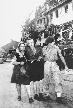 A British soldier removes refugees, wounded resisting the British, from the ship "Exodus 1947."