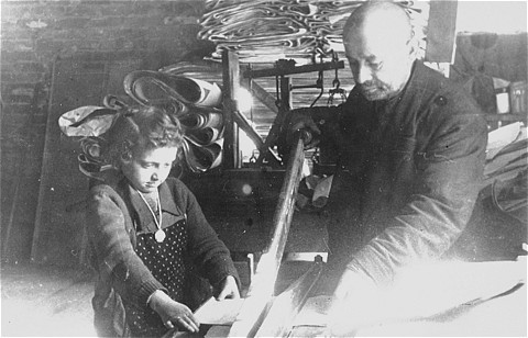 A Jewish man and child at forced labor in a factory in the Lodz ghetto.