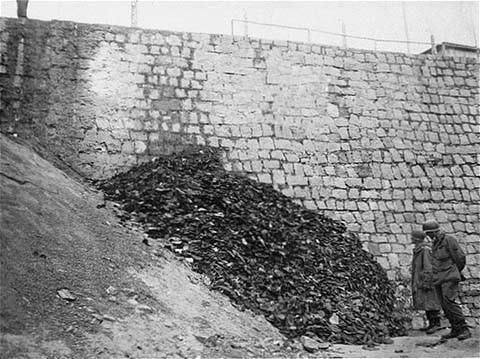 After the liberation of the Flossenbürg concentration camp, two US army infantrymen examine a pile of shoes belonging to victims ... [LCID: 77028]