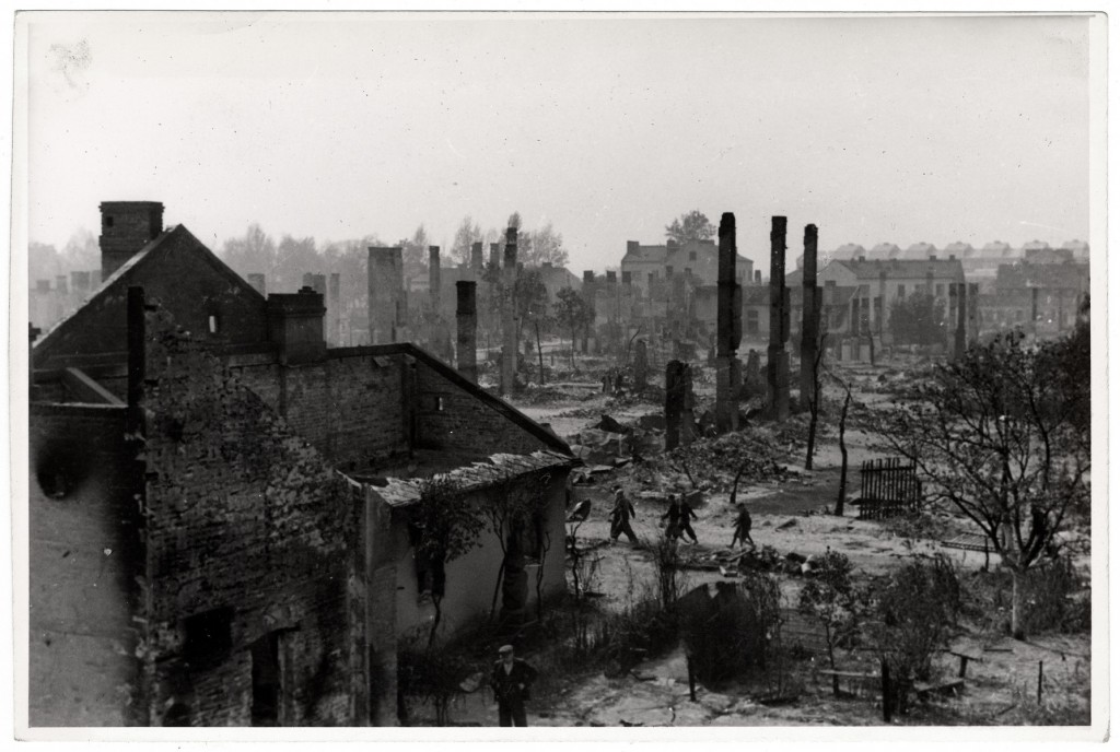 Poles walk among the ruins of besieged Warsaw. [LCID: 47270]