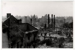 Poles walk among the ruins of besieged Warsaw.
This photograph documenting war destruction was taken by Julien Bryan  (1899-1974), a documentary filmmaker who filmed and photographed the everyday life and culture of individuals and communities in various countries around the globe.