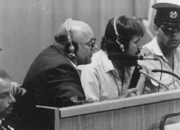 L'accusé John Demjanjuk commente des documents visionnés sur un grand écran au tribunal. Jérusalem, Israël, 27 juillet 1987.