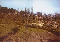 Soldados estadounidenses observan mientras civiles alemanes entierran los cadáveres de prisioneros hallados en el campo de concentración de Nordhausen. Nordhausen, Alemania, 13-14 de abril de 1945.