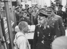 Heinrich Himmler, kepala SS, berbicara kepada seorang tahanan kamp konsentrasi Dachau saat inspeksi resmi. Dachau, Jerman, 8 Mei 1936.