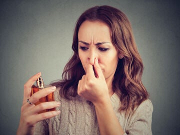 Mujer oliendo un perfume