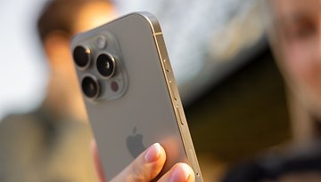 A close-up of an iPhone 16 Pro held in hand, showcasing its camera and buttons.