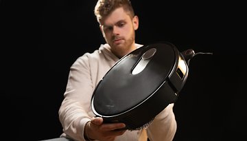 Roborock Qrevo Slim im Vordergrund, gehalten von einer Person