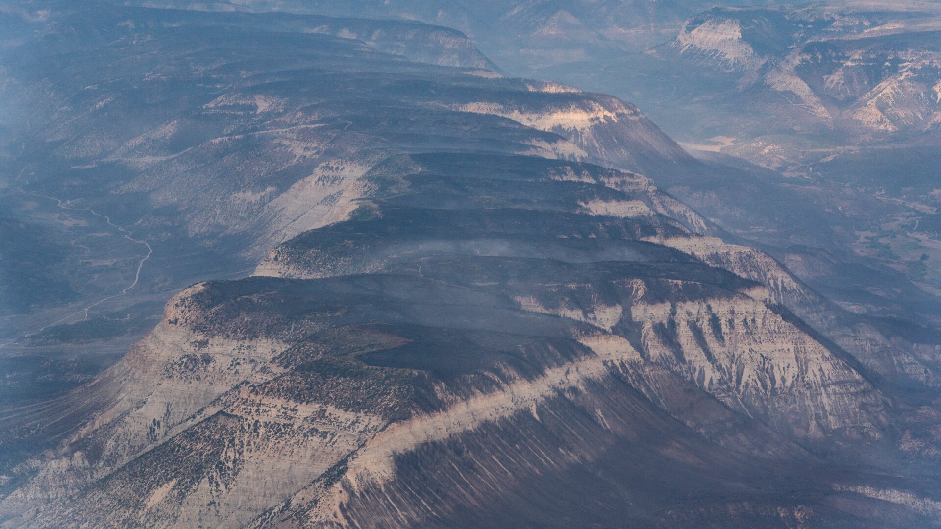 Mountain tops burned by the Pine Gulch Fire sit cleared of fire activity on August 26, 2020 in Grand Junction, Colorado.