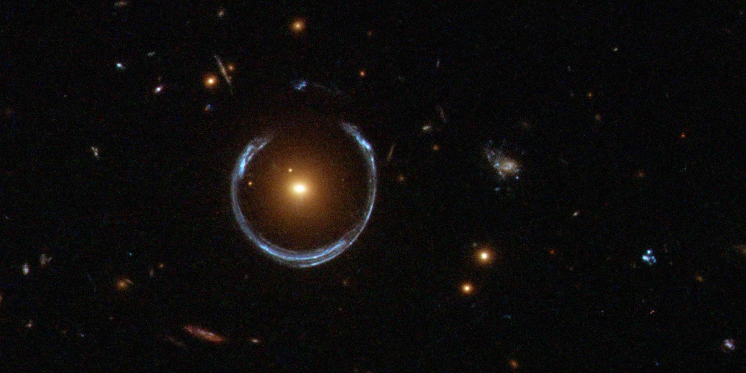 An Einstein Ring encircles a luminous red galaxy, a glaring example of gravitational lensing.