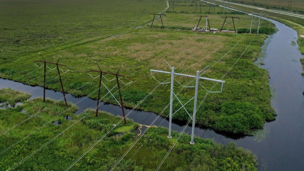 In an aerial view, electric power lines are seen attached to the transmission tower along the power grid on September 28, 2023 in the Everglades, Florida.