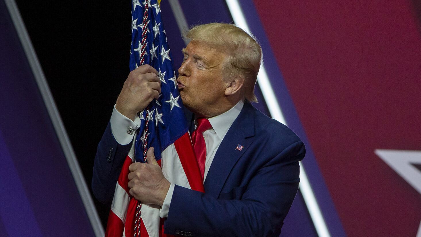 President Donald Trump kisses the flag of the United States of America at the annual Conservative Political Action Conference (CPAC) at Gaylord National Resort & Convention Center February 29, 2020 in National Harbor, Maryland.