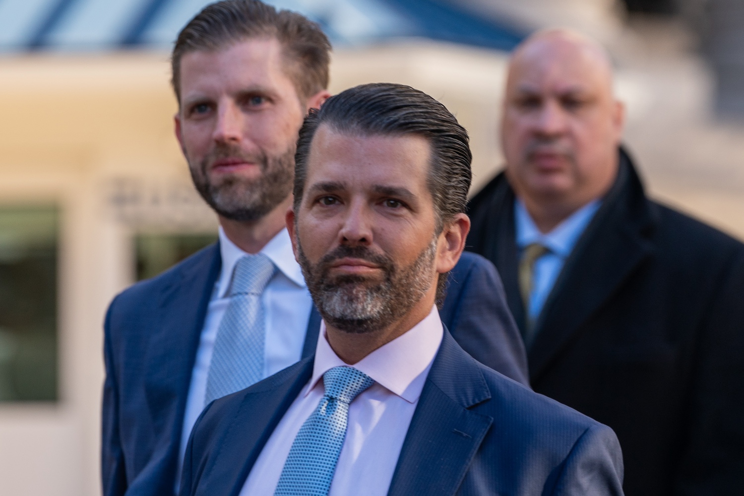 Photo of Donald Trump Jr. and Eric Trump flanked by security.