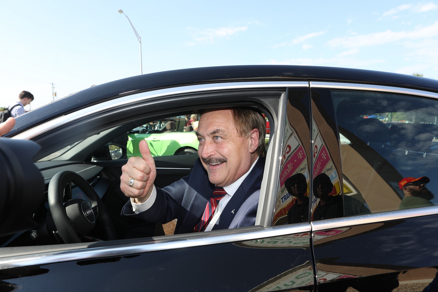 MyPillow CEO Mike Lindell gives the thumb's up from a moving car