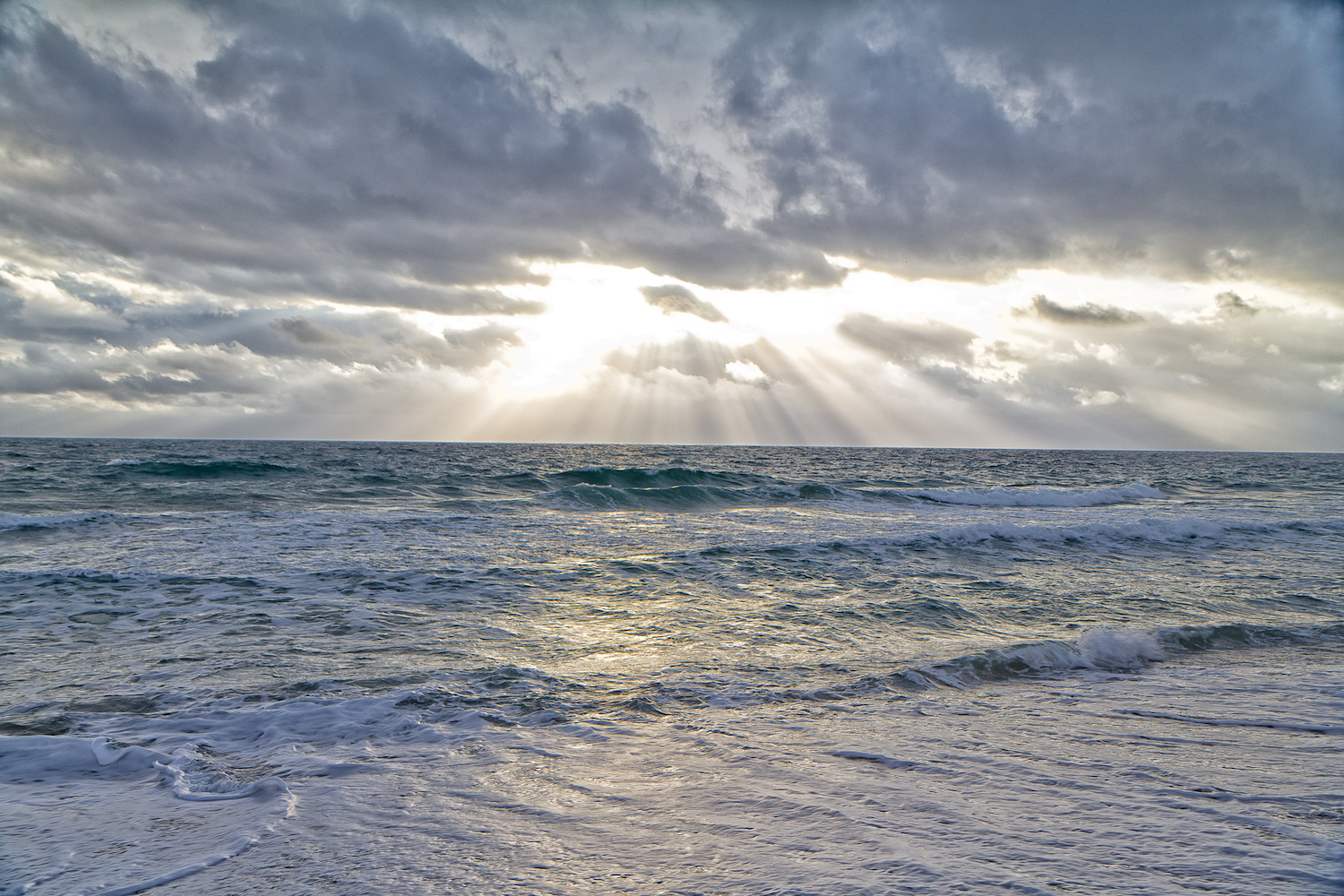 Picture of sun coming through clouds above Atlantic Ocean