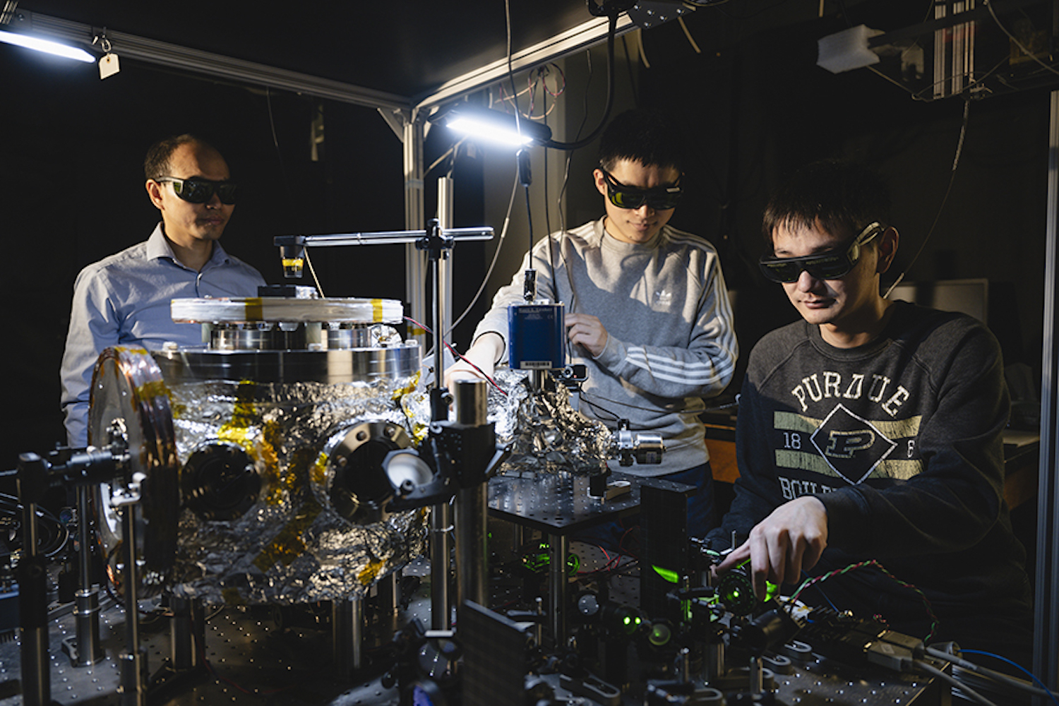 Picture of Purdue scientists perform experimenting with levitated and rotating fluorescent diamonds