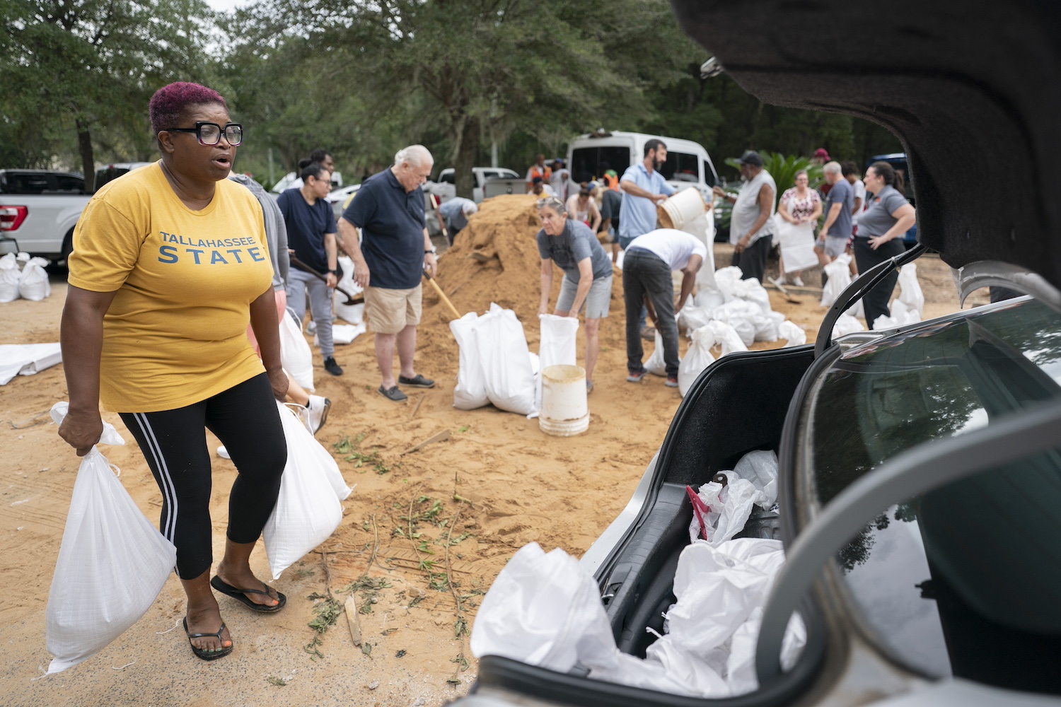 Tallahassee State professor Pamela Andrews carriers sand bags to a car in preparation for possible flooding as Tropical Storm Helene heads toward the state's Gulf Coast in Tallahassee, Florida.