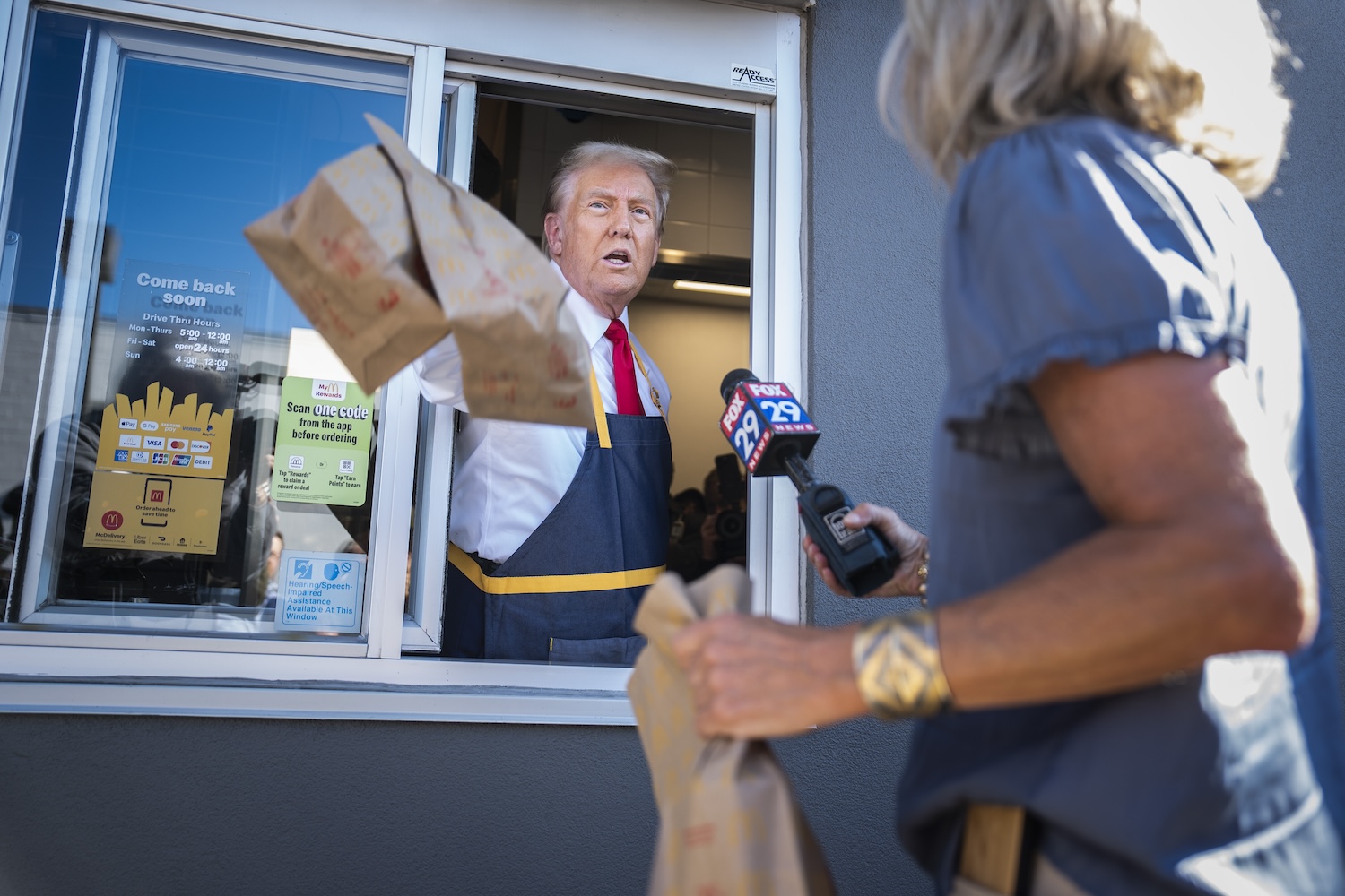 President Trump handing out a McDonald's order through the serving window.