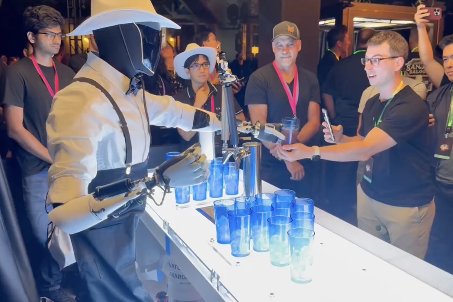 A human-assisted Tesla robot known as Optimus pouring drinks at an event Oct. 10, 2024 at Warner Bros. in Burbank, California.