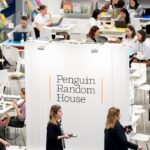 A room full of people at tables surrounding a large sign reading 'Penguin Random House'