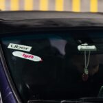 Uber and Lyft logos displayed in a car's windshield.