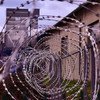 Barbed wire fencing surrounds a detention centre.