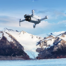 Potensic drone flying above snowy mountain tops 