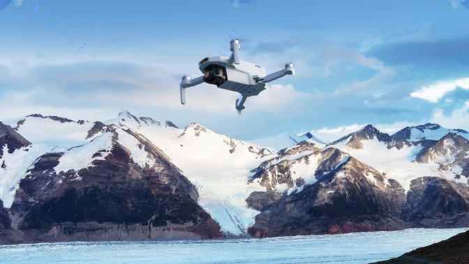 Potensic drone flying above snowy mountain tops 