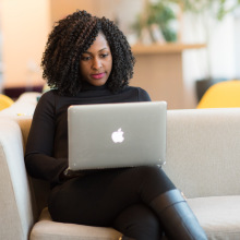 Woman Using Macbook Sitting on White Couch