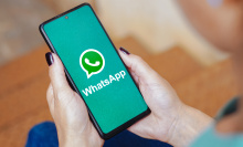 The WhatsApp logo is displayed on a smartphone screen. 